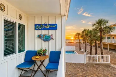 The balcony. Sunset over the Gulf, pool below, palm shadows, and a seat waiting. This is the payoff for a slow day.