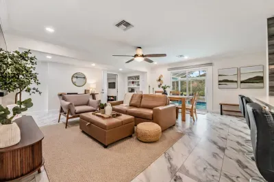Bright, open-concept living space with stylish seating, plush sectional, and seamless flow to dining and outdoor areas. Perfect for relaxing after a day of fun, gathering with loved ones, or enjoying cozy movie nights in comfort and style.
