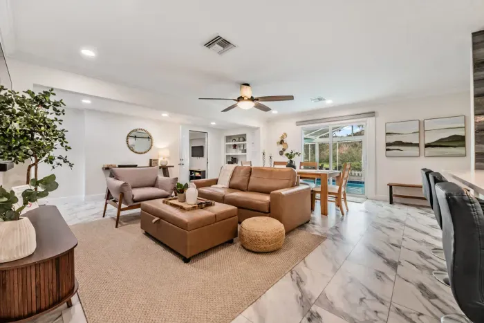 Bright, open-concept living space with stylish seating, plush sectional, and seamless flow to dining and outdoor areas. Perfect for relaxing after a day of fun, gathering with loved ones, or enjoying cozy movie nights in comfort and style.