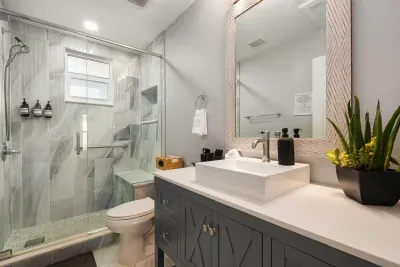 Refresh in this modern bathroom featuring a walk-in glass shower, stylish vanity, and spa-like finishes. Bright, clean, and thoughtfully designed for a relaxing and comfortable stay.