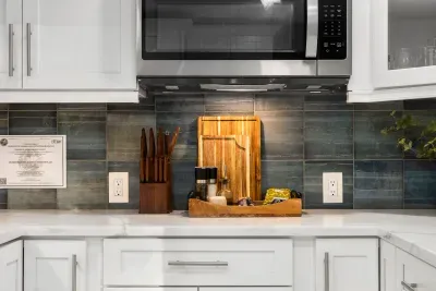 This stylish kitchen workspace features modern cabinetry, sleek backsplash, and ample prep space. Thoughtfully designed for easy cooking, it’s perfect for whipping up meals or enjoying a relaxed night in.