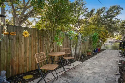 Enjoy this charming garden walkway with bistro seating tucked among lush plants and warm décor. A cozy spot for morning coffee, quiet conversations, or a peaceful escape surrounded by nature.