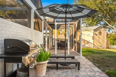 Fire up the grill on this inviting patio with lounge chairs, umbrella shade, and screened comfort. Ideal for BBQs, relaxing afternoons, or unwinding outdoors while enjoying fresh air and privacy.