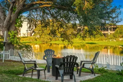 Unwind by the peaceful lake with cozy Adirondack seating and a crackling fire pit beneath shady trees. Enjoy morning coffee or sunset conversations with tranquil water views, gentle breezes, and a truly relaxing outdoor retreat.