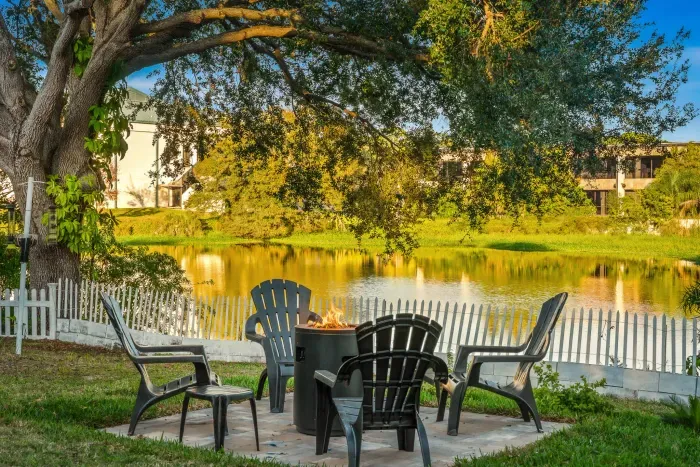 Unwind by the peaceful lake with cozy Adirondack seating and a crackling fire pit beneath shady trees. Enjoy morning coffee or sunset conversations with tranquil water views, gentle breezes, and a truly relaxing outdoor retreat.