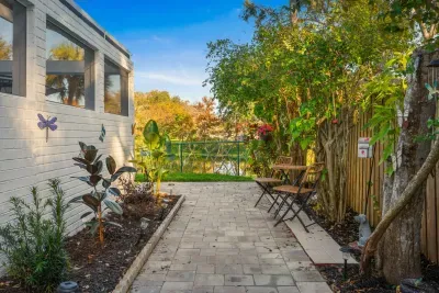 Wander through this tranquil garden path lined with lush greenery and cozy bistro seating. A peaceful outdoor nook perfect for morning coffee, quiet moments, or enjoying the home’s serene surroundings.