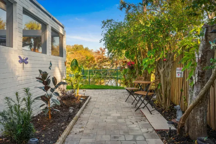 Wander through this tranquil garden path lined with lush greenery and cozy bistro seating. A peaceful outdoor nook perfect for morning coffee, quiet moments, or enjoying the home’s serene surroundings.