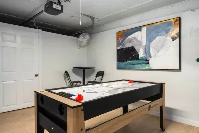 Have fun in the game room featuring a modern shuffleboard table and casual seating. A perfect spot for friendly competition, laid-back hangouts, and entertaining evenings during your stay.