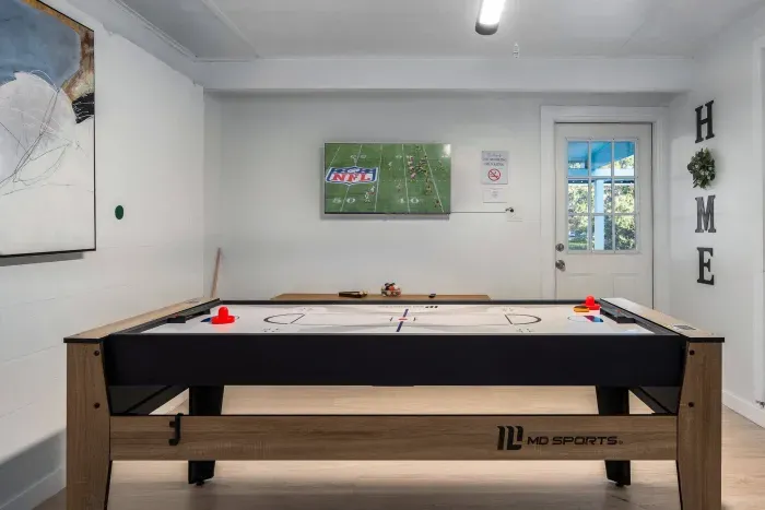 Challenge friends in the game room featuring a sleek shuffleboard table. Perfect for game nights, friendly competition, and relaxing indoors, comfort to your stay.