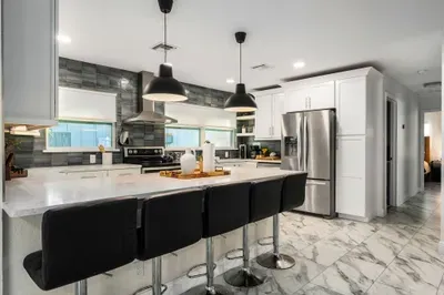 Enjoy this spacious, modern kitchen with a large island, sleek bar seating, and stainless steel appliances. Designed for convenience and style, it’s ideal for group meals, entertaining, and everyday cooking.