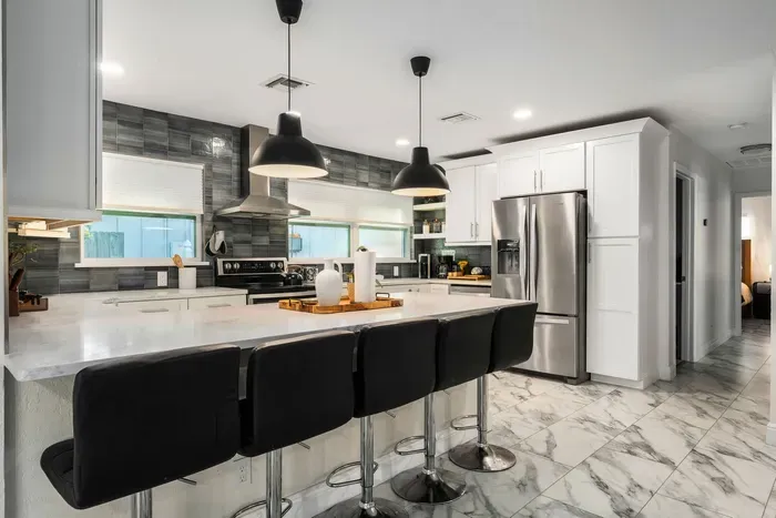 Enjoy this spacious, modern kitchen with a large island, sleek bar seating, and stainless steel appliances. Designed for convenience and style, it’s ideal for group meals, entertaining, and everyday cooking.
