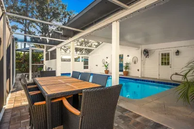 Enjoy meals poolside at the spacious outdoor dining table, set beneath a covered patio with views of the sparkling private pool. Perfect for alfresco dinners, morning coffee, and relaxed gatherings in a resort-style setting.