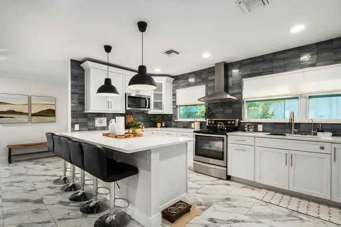 Experience this bright, chef-inspired kitchen with a large island, bar seating, and sleek modern finishes. Fully equipped and spacious, it’s perfect for cooking, entertaining, and gathering with ease.