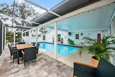 Sun-soaked screened pool oasis with covered patio dining, cozy seating, and tropical vibes. Swim, relax, or dine al fresco year-round in this private retreat—perfect for families, friends, and unforgettable Florida nights.