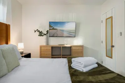 Enjoy this cozy, well-appointed bedroom with a wall-mounted TV, plush bedding, and calming décor. Perfect for unwinding, streaming your favorites, and settling into a restful night’s sleep.