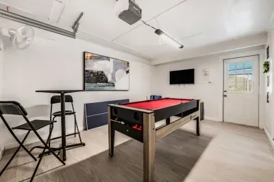 Fun-filled game room perfect for friendly competition! Enjoy pool, bar seating, TV entertainment, and a bright modern space to unwind. Ideal for game nights, family fun, and relaxing between adventures.