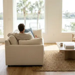 Man relaxes on sofa, enjoying water view