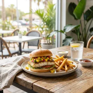 Fish burger with fries and a drink at a beachside cafe