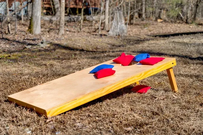 Fun Outdoor Game Area: Challenge friends to a thrilling cornhole tournament in nature!