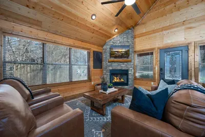 Living Room: Warm up by the stylish stone fireplace and enjoy views through giant windows!