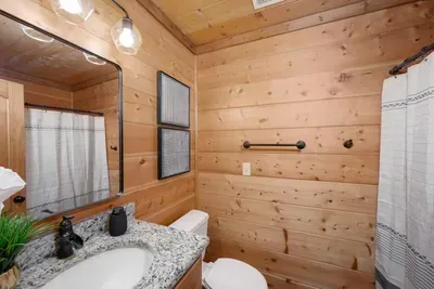 Bathroom Oasis: Enjoy the sleek granite counter and warm, wood-paneled ambiance for ultimate relaxation!