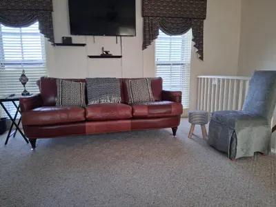 Cozy loft lounge with leather sofa, TV, and abundant natural light
