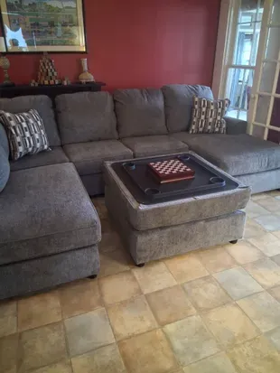 Cozy lounge with plush sectional, ottoman tray, and chess set.
