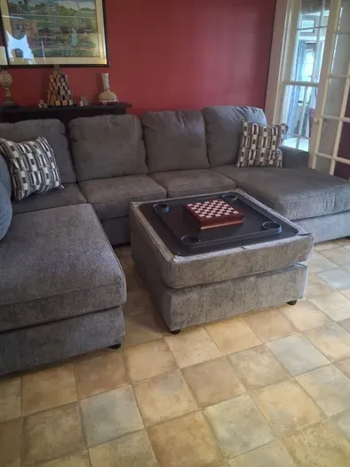 Cozy lounge with plush sectional, ottoman tray, and chess set.