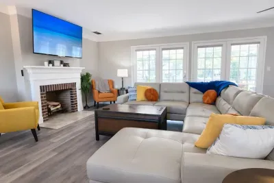 Sunlit living room with huge sectional, fireplace & smart TV