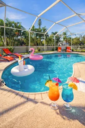 Private screened pool with loungers, fun floats, and tropical vibes