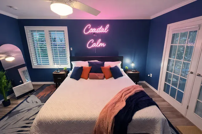 Coastal-chic retreat: neon mood lighting, French doors, plush queen bed