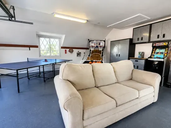 Fun-filled game room with ping pong, arcade games, and cozy seating