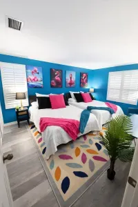 Colorful tropical bedroom with two comfy beds, shutters, and sunny vibe