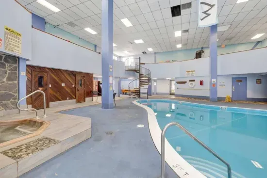 Spacious indoor pool with hot tub, sauna, and mezzanine lounge.