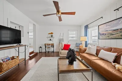 Bright lounge with leather sofa, TV, desk nook & hardwood floors