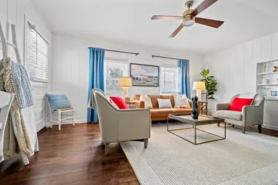 Sunny, stylish living room—leather sofa, hardwood floors, and modern comforts.