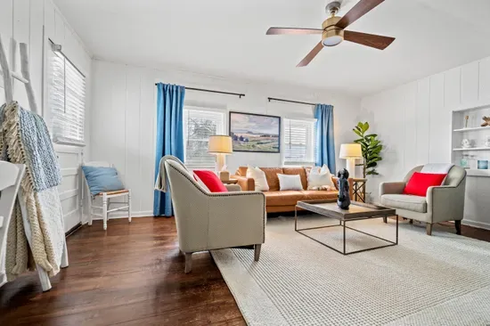 Sunny, stylish living room—leather sofa, hardwood floors, and modern comforts.