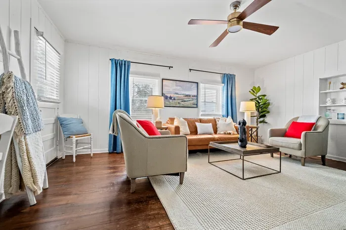 Sunny, stylish living room—leather sofa, hardwood floors, and modern comforts.