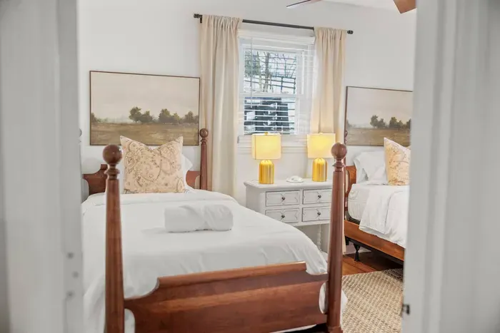 Bright twin room with classic wood beds, fresh linens, and warm lighting