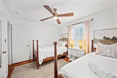 Bright twin-room with ceiling fan, hardwoods, and cozy decor