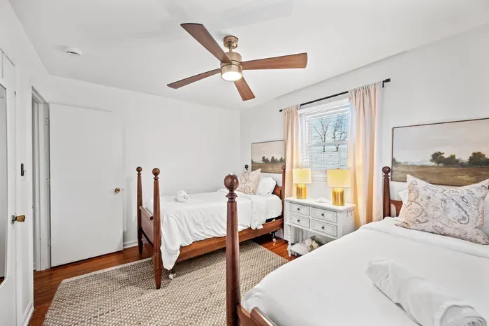 Bright twin-room with ceiling fan, hardwoods, and cozy decor