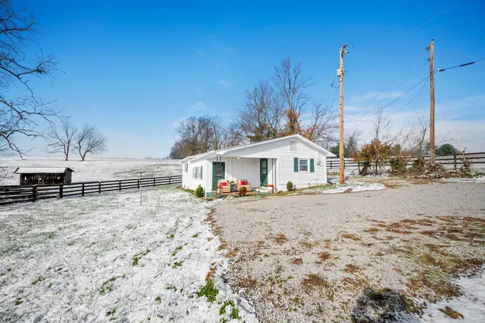 Cozy country cottage with porch seating and sweeping pasture views.