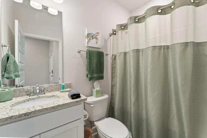 Shared bathroom with bunk room and calming coastal king bedroom.