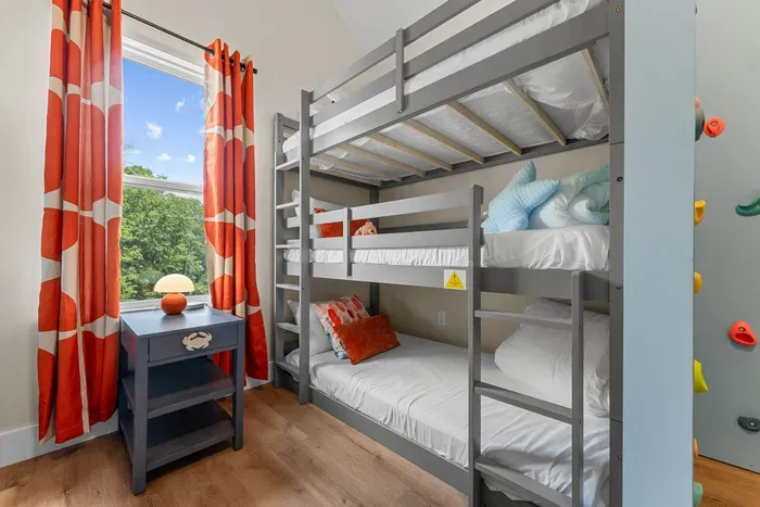 A dream room for kids! With 6 beds, a slide, and a climbing wall, the fun never has to stop. 🧗