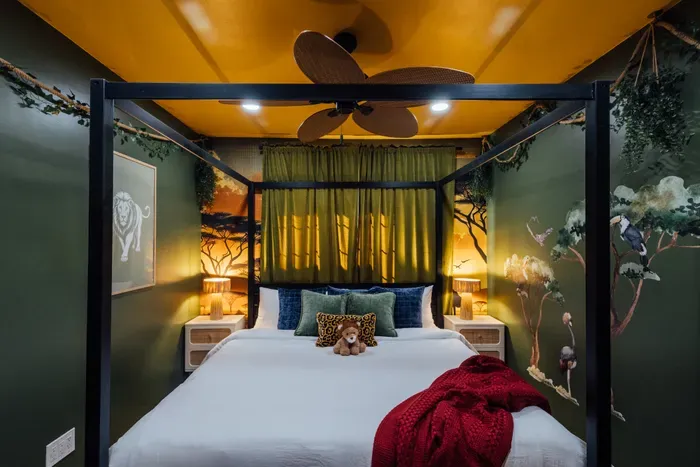 Themed jungle-inspired bedroom with a cozy king bed, warm lighting, and stylish safari decor for a unique and relaxing stay.