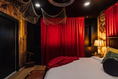 Immersive Pirates of the Caribbean–inspired bedroom with a striking black accent wall and detailed décor for a unique, adventure-filled stay.