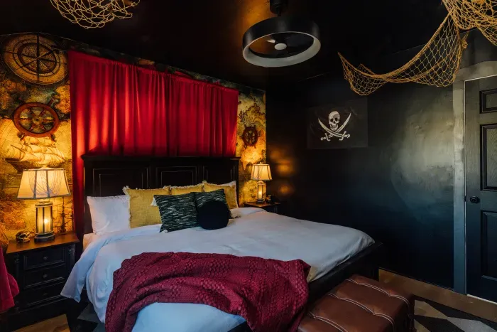 An adventure-filled Pirates of the Caribbean–inspired bedroom designed with a bold black accent wall and detailed pirate-themed accents.