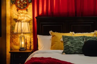 A themed bedroom inspired by Pirates of the Caribbean, showcasing a bold black accent wall and immersive décor that creates a fun, story-like experience.