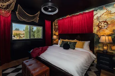 Themed bedroom inspired by Pirates of the Caribbean, featuring a dramatic black wall and immersive pirate-style details.