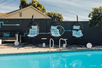 Relaxing pool area featuring a hanging chair, perfect for lounging, unwinding, and enjoying a peaceful outdoor vibe.